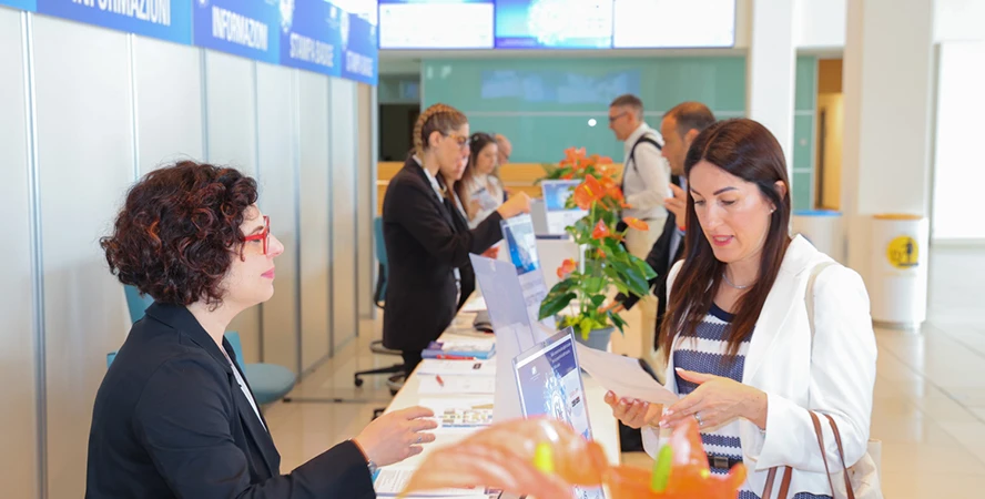Lo staff di AFI Scientifica accoglie i partecipanti al bancone iscrizioni del simposio