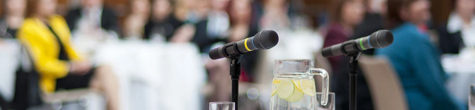 Pubblico di professionisti che ascolta una conferenza scientifica durante il Simposio AFI, con microfoni in primo piano.